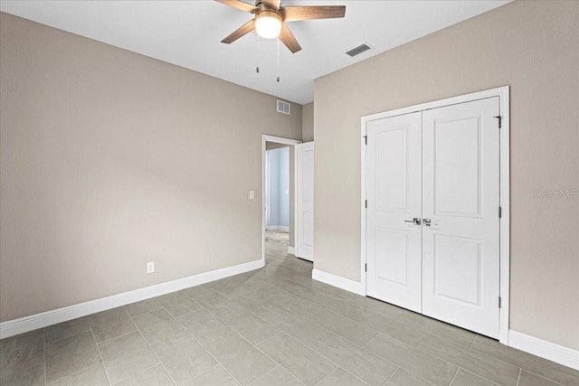 unfurnished bedroom featuring ceiling fan and a closet