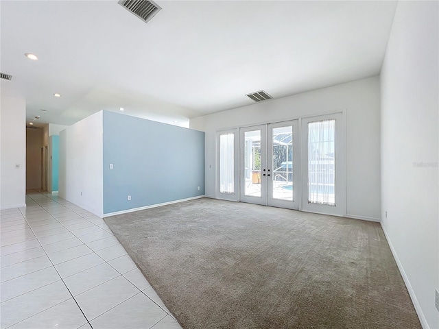 unfurnished room with light carpet and french doors