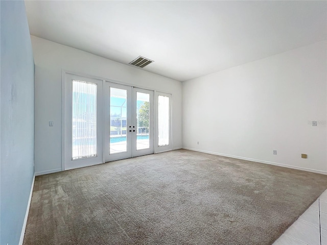 unfurnished room with french doors and light carpet