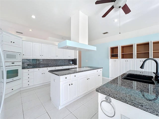 kitchen with white appliances, island range hood, and white cabinets