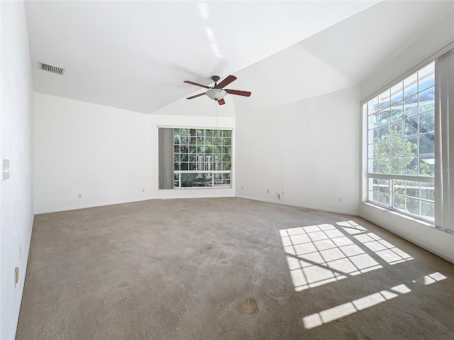 empty room with vaulted ceiling, ceiling fan, and carpet floors