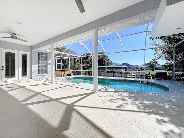 view of swimming pool featuring a patio, glass enclosure, and a jacuzzi