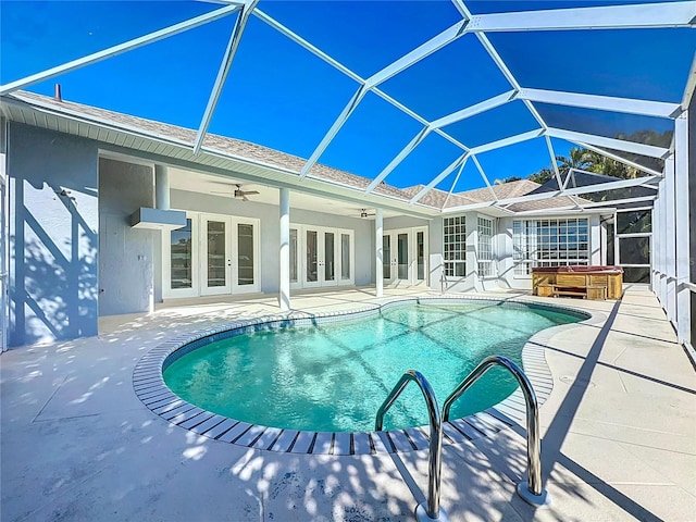 view of pool with french doors, a hot tub, a lanai, ceiling fan, and a patio