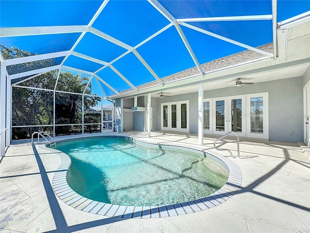 view of pool with a patio, glass enclosure, ceiling fan, and french doors