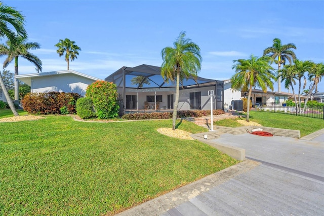 ranch-style home with a lanai, a front lawn, and central air condition unit