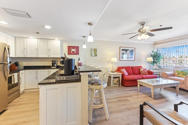 kitchen with white cabinetry, hanging light fixtures, stainless steel appliances, and light hardwood / wood-style floors