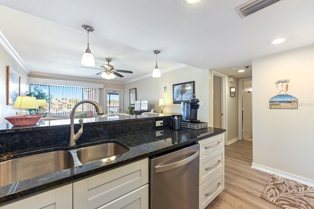 kitchen featuring white cabinetry, crown molding, stainless steel dishwasher, pendant lighting, and dark stone counters