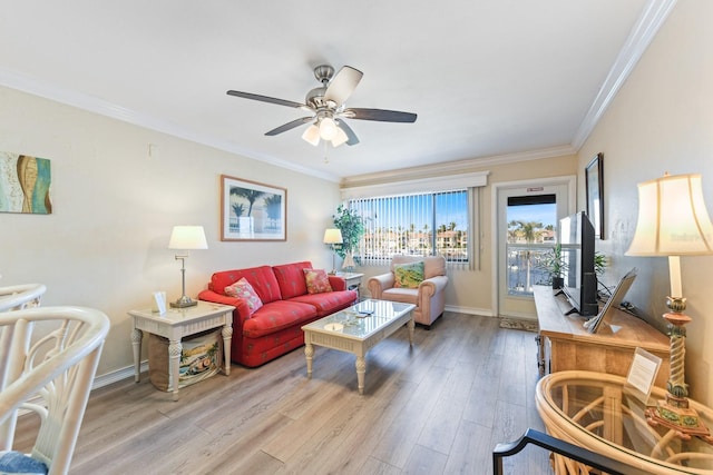 living room with ornamental molding, light hardwood / wood-style floors, and ceiling fan