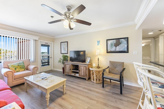 living room with hardwood / wood-style flooring, crown molding, and ceiling fan