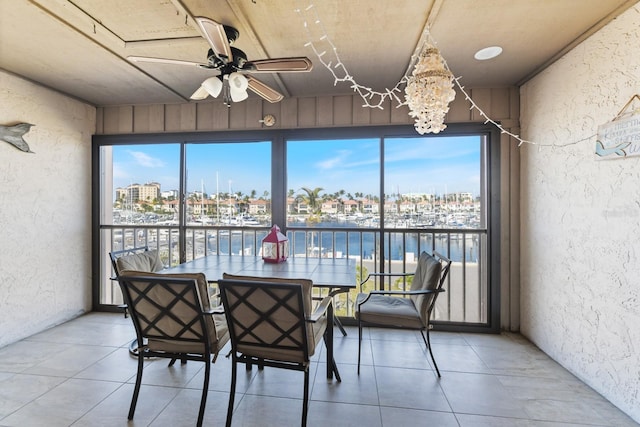 unfurnished sunroom with a water view and ceiling fan with notable chandelier