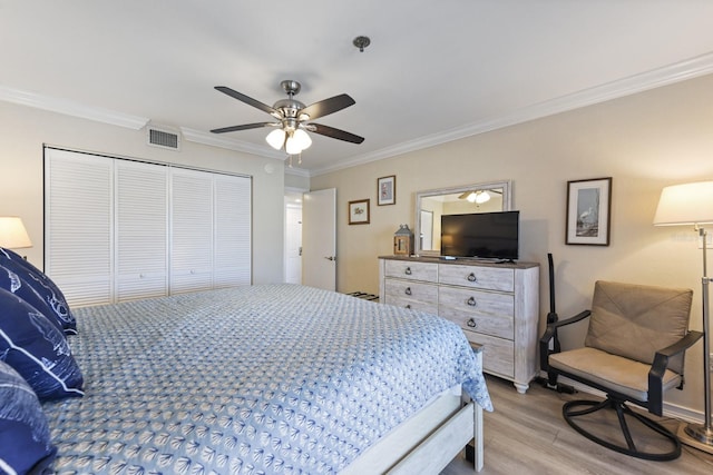 bedroom with light hardwood / wood-style flooring, ornamental molding, a closet, and ceiling fan