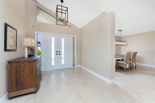 entrance foyer featuring high vaulted ceiling, french doors, and a chandelier