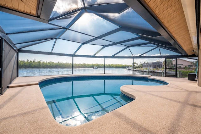 view of swimming pool featuring a patio area, glass enclosure, and a water view