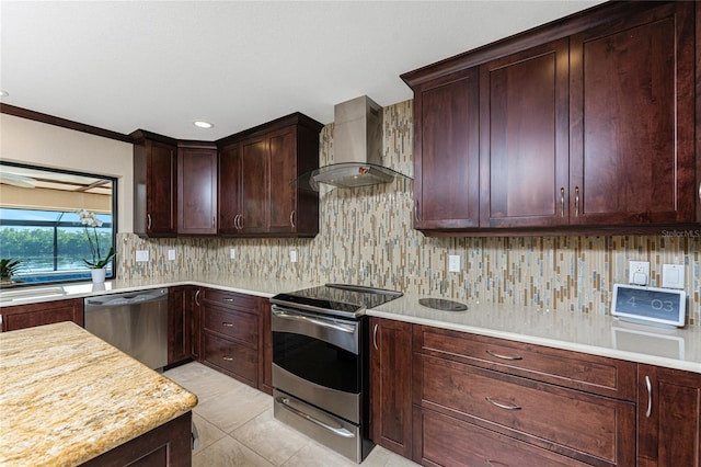 kitchen featuring wall chimney range hood, light tile patterned floors, backsplash, stainless steel appliances, and light stone countertops