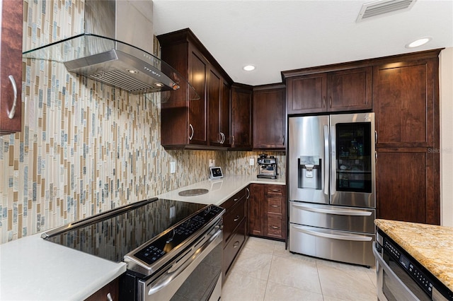 kitchen with light tile patterned floors, dark brown cabinets, stainless steel appliances, ventilation hood, and decorative backsplash