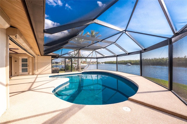 view of pool with a water view, a patio area, and glass enclosure