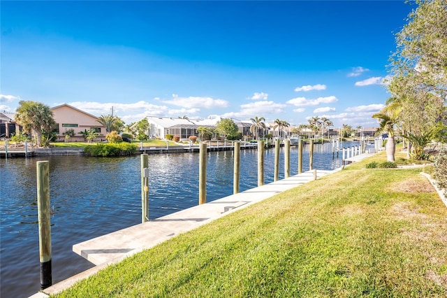 dock area with a water view and a lawn