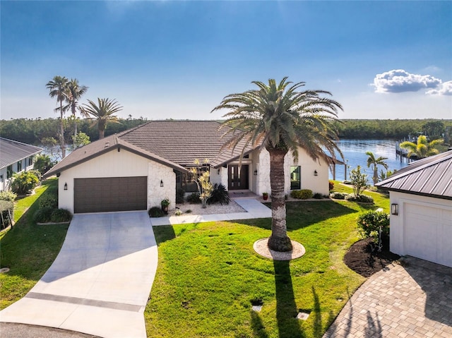 view of front facade featuring a garage, a water view, and a front yard