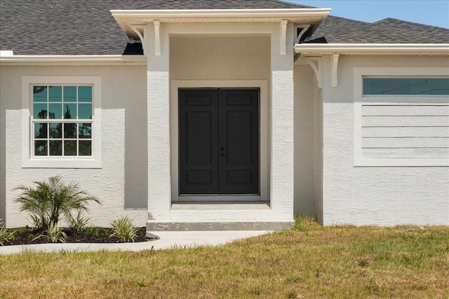 doorway to property with a lawn