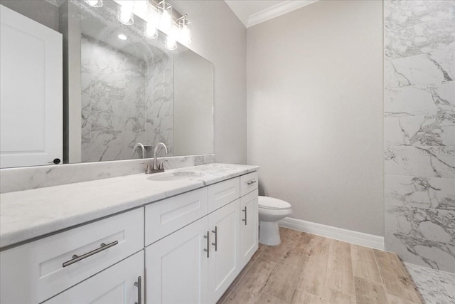 bathroom featuring vanity, hardwood / wood-style flooring, crown molding, and toilet