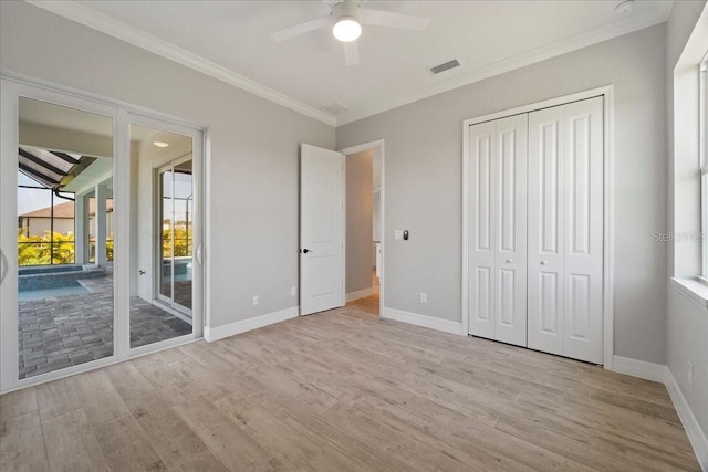 unfurnished bedroom with light hardwood / wood-style flooring, ornamental molding, a closet, and access to outside