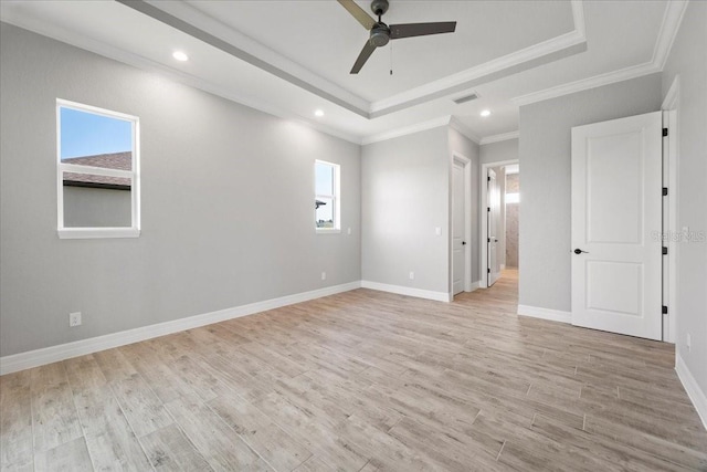 unfurnished room with crown molding, ceiling fan, a raised ceiling, and light wood-type flooring