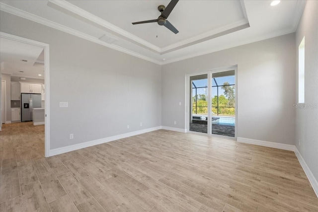 unfurnished room featuring crown molding, ceiling fan, a raised ceiling, and light hardwood / wood-style floors