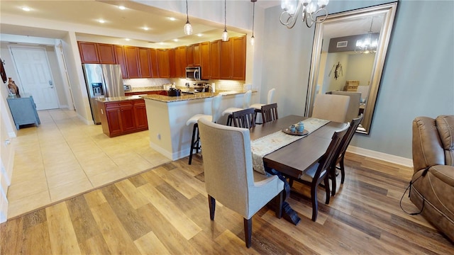 dining room with light hardwood / wood-style flooring and a chandelier