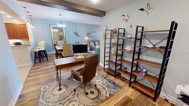 office space with light hardwood / wood-style floors and a chandelier