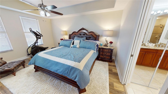 tiled bedroom featuring ensuite bath and ceiling fan