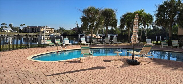 view of pool featuring a water view and a patio area