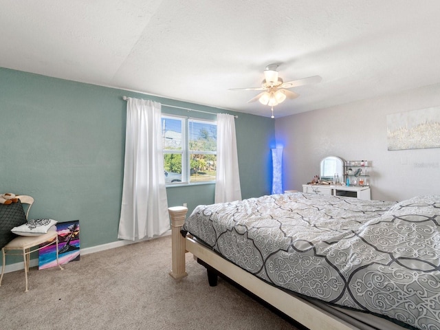 bedroom featuring ceiling fan, light carpet, and a textured ceiling