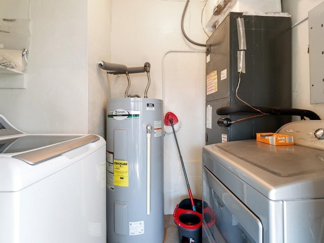 clothes washing area with washing machine and clothes dryer, electric panel, and electric water heater