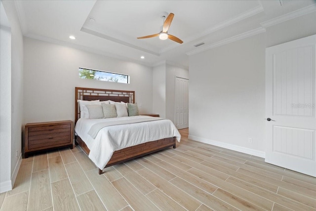 bedroom featuring ceiling fan, ornamental molding, and a tray ceiling