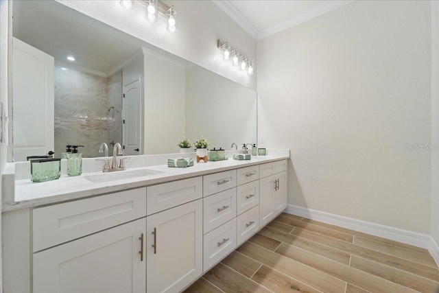 bathroom with crown molding, vanity, and a tile shower