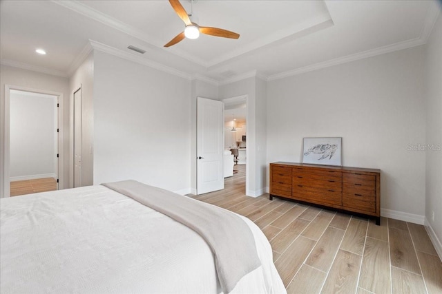 bedroom with ceiling fan, ornamental molding, and a tray ceiling