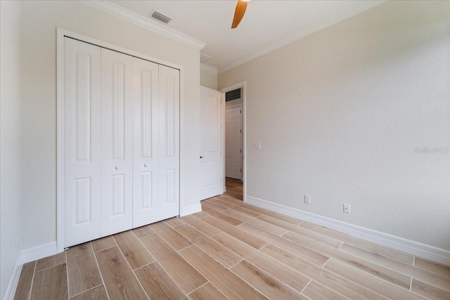 unfurnished bedroom featuring ceiling fan, ornamental molding, and a closet