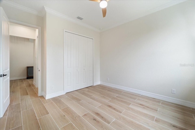 unfurnished bedroom with crown molding, a closet, and ceiling fan