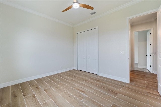 unfurnished bedroom with ornamental molding, a closet, and ceiling fan