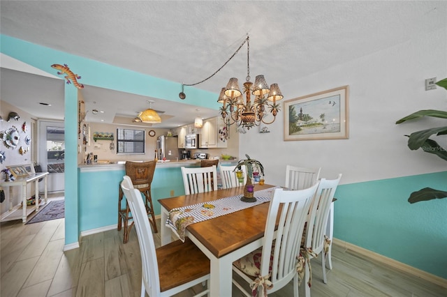 dining room with a textured ceiling and light wood-type flooring