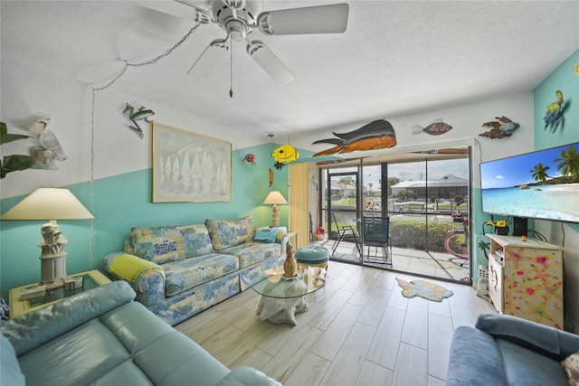 living room featuring a textured ceiling, ceiling fan, and light hardwood / wood-style floors