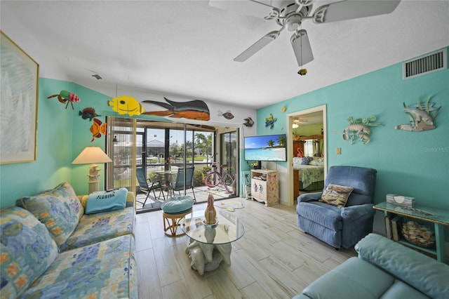 living room featuring ceiling fan and light hardwood / wood-style floors