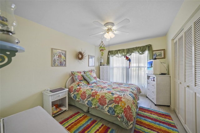 bedroom featuring ceiling fan, light hardwood / wood-style floors, and a closet