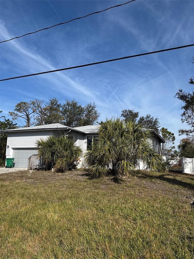 view of property exterior featuring a garage and a yard