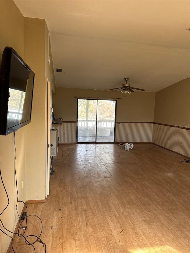 unfurnished living room featuring ceiling fan and light hardwood / wood-style floors