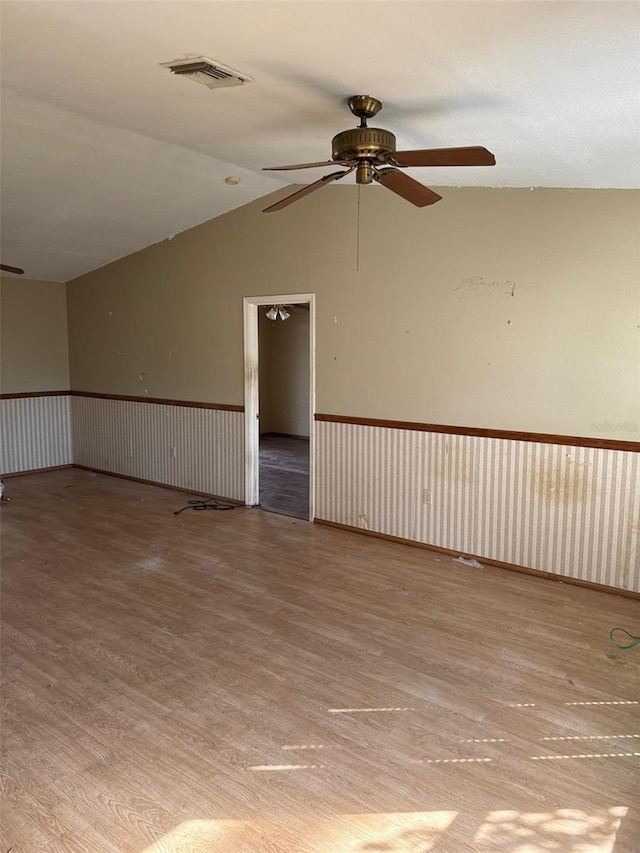 spare room featuring ceiling fan, lofted ceiling, and light hardwood / wood-style flooring