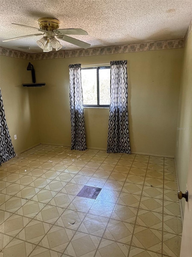 unfurnished room featuring ceiling fan and a textured ceiling