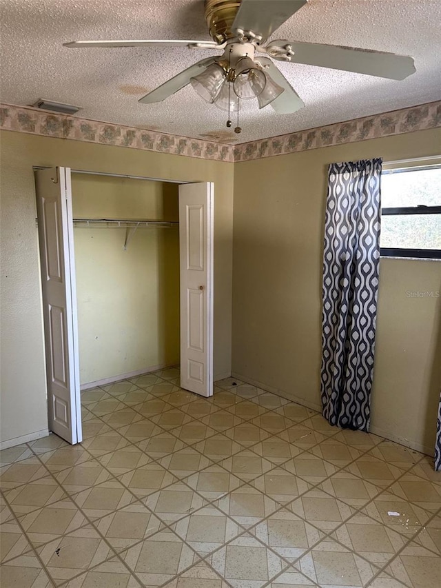 unfurnished bedroom with ceiling fan, a closet, and a textured ceiling