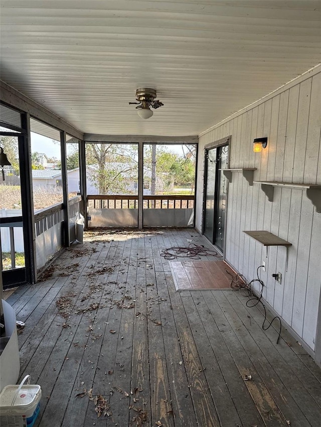 unfurnished sunroom featuring ceiling fan