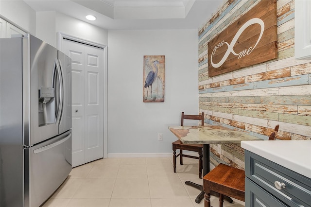 kitchen featuring wood walls, white cabinetry, gray cabinetry, light tile patterned floors, and stainless steel fridge with ice dispenser